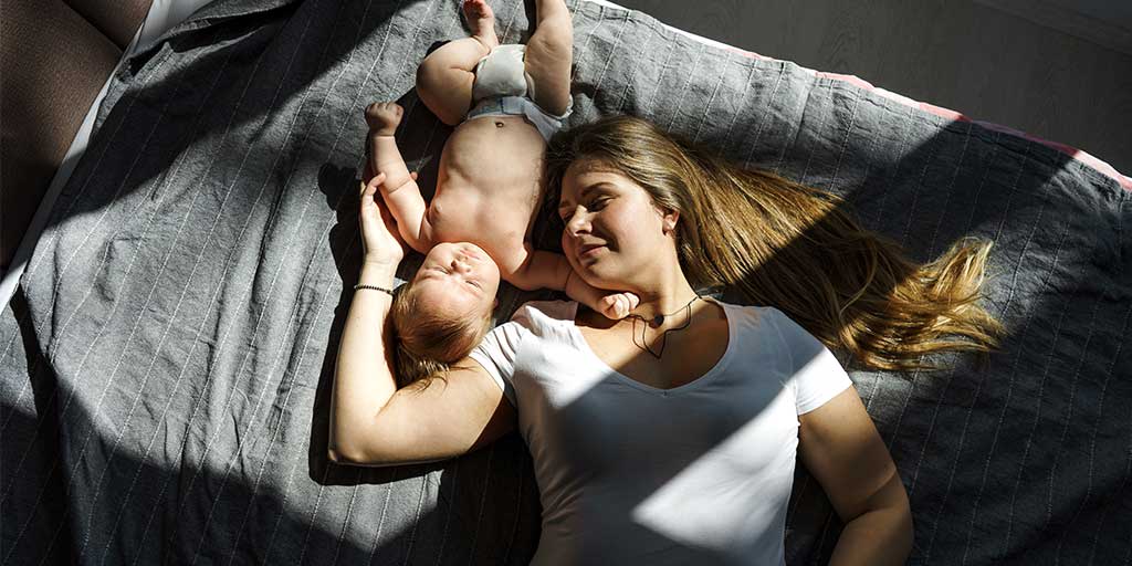 mumandbaby mother and baby lying on a bed